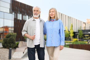 Lovely senior couple walking together on city street
