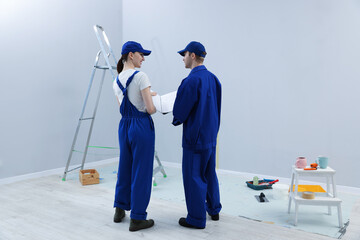Workers looking at design project in room, back view
