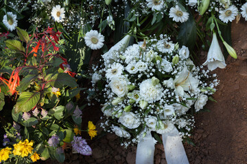 Nach der Beisetzung, Trauer am Grab mit Blumen