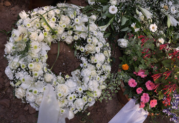 Nach der Beisetzung, Trauer am Grab mit Blumen