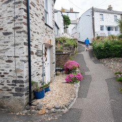 old narrow street with man in cornish village of port isaac on sunny spring day
