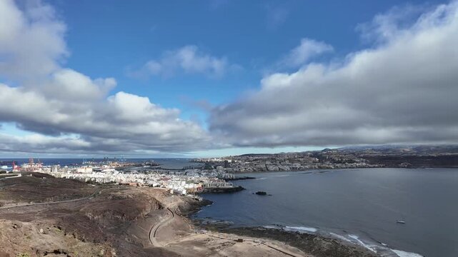 An elevated view of Las Palmas de Gran Canaria city. Timelapse of the city under a fast changing sky with layers of clouds under a blue sky.