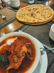 Borscht with meat and khachapuri on a table