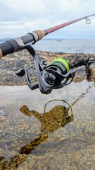 Spinning Fishing Rod and reel on Coastal Rocks with Ocean in Background  Outdoor Angling Scene, Coastal Fishing Adventure