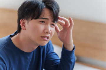 ベッドで落ち込む男性