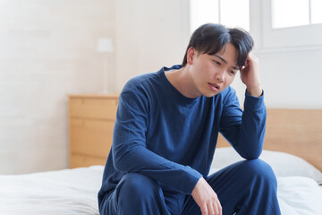 ベッドで落ち込む男性