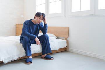 ベッドで落ち込む男性