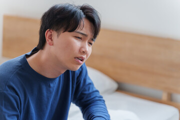 ベッドで落ち込む男性