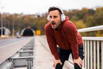 Man Resting After Intense Run on a Bridge