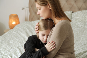 Loving worried mom consoling her sad little girl