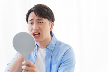 歯をチェックする男性
