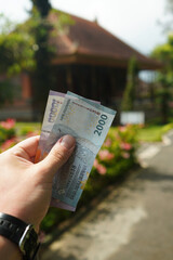 Indonesian rupiah. Balinese rupiah in hand