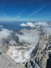 Drone view of the Zugspitze summit, Germany’s highest peak in the Bavarian Alps. The aerial photo captures the mountain station, observation platforms, rugged cliffs, and the breathtaking alpine