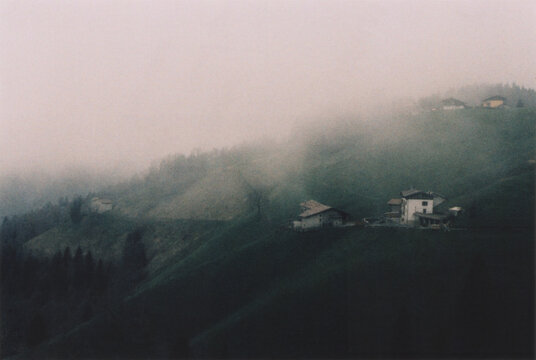 Italian Mountain Village View in the Fog. Beautiful Atmospheric Landscape in the Italian Alps, Bergamo Province. Film Photography