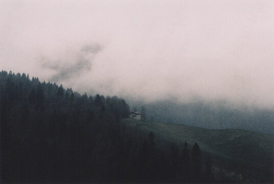 Ancient Italian Stone Mountain House at the Edge of the Forest during a Spring Cloudy Day. Bergamo Alps, Italy. Film Photography