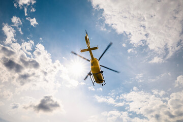 Flying helicopter of emergency medical service on sky on sunny day. Themes urgency, rescue and hope.