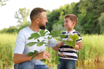 Father and his son planting tree outdoors