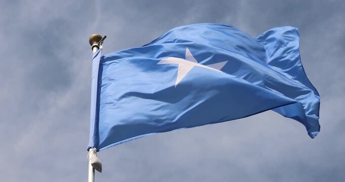 The Somali flag is captured in close-up. The Somali flag fluttering against the blue sky is the national symbol of Somalia. Great for news. The video is presented in 4K format.