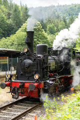 Vintage Steam Locomotive in Motion at Rural Railway Station – Historic Train with Smoke and Steam