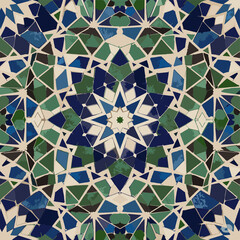 Intricate seamless mosaic pattern with traditional geometric designs in shades of blue and green, set on a beige background with a distressed texture.