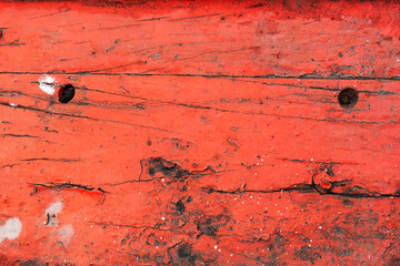 The red wooden background has small white spots and dirty black scratches.