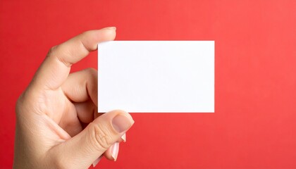 Obraz premium Hand holding blank white card against solid red background