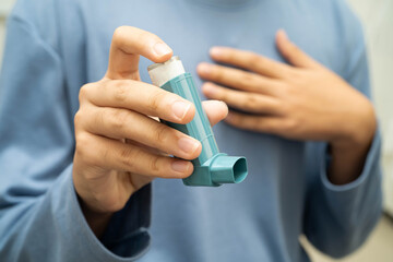 Asthma and chronic obstructive pulmonary disease COPD, Asian young man using metered dose inhaler...