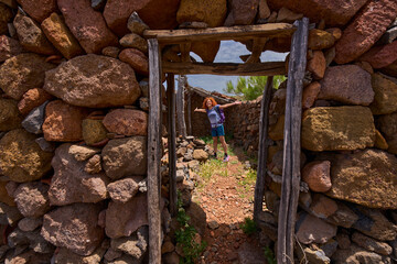 Hiker showing stone shelter in Teno