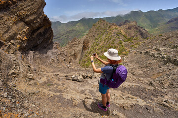 Hiker taking photo on mountain ridge