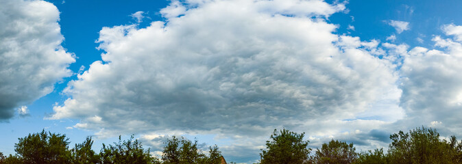 Clouds in blue sky over countryside on summer day. Natural summer cloudy sky background