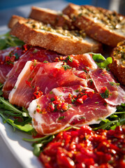 Obraz premium Cured ham with chili herb garnish and toasted bread on arugula