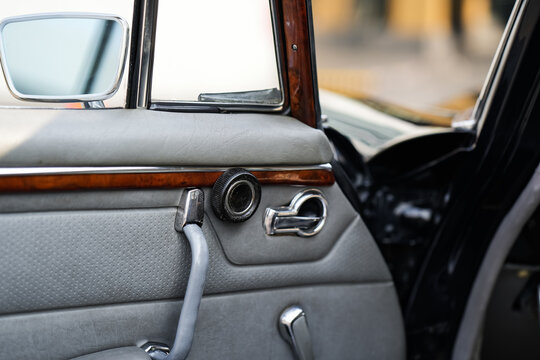 The inner door handles of a vintage car are captured in a clean view, reflecting the classic design and preserved components that represent the simplicity and authenticity of vintage cars.