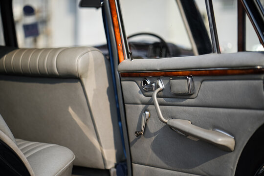 The inner door handles of a vintage car are captured in a clean view, reflecting the classic design and preserved components that represent the simplicity and authenticity of vintage cars.