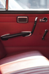 The inner door handles of a vintage car are captured in a clean view, reflecting the classic design...