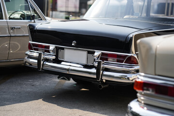 The position and mounting of license plates on classic cars, showing standard rear placement with...