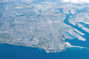 Aerial view of Los Angeles, California coastline with San Pedro and Long Beach port area with Cabrillo Marina against blue sky with clouds