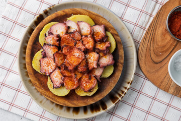 Delicious pulpo a la gallega, spanish octopus dish, sitting on potatoes with paprika
