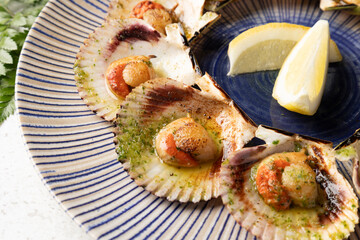 Grilled scallops with lemon and parsley butter sauce on elegant plate