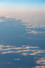 Aerial view of the winding Missouri River running through South Dakota, USA, seen through scattered clouds at high altitude during a flight