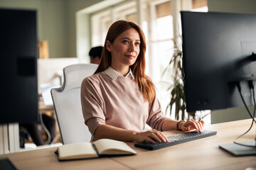 Professional Woman Working at a Modern Office Desk with Computer