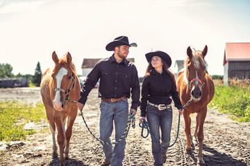 couple boyboy and girl, stands next to her horse in summer season