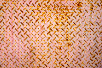 Close up of rusty diamond plate metal with a pinkish tone. Industrial texture background ideal for...