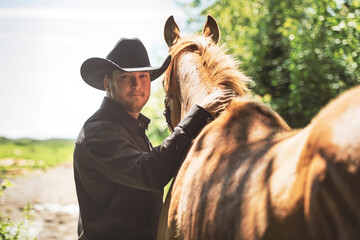 cowboy, stands next to her horse in summer season