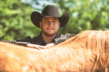 cowboy, stands next to her horse in summer season