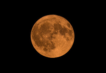 Full Buck moon glowing orange just above the horizon over Ottawa, Canada, July 10, 2025 against a...