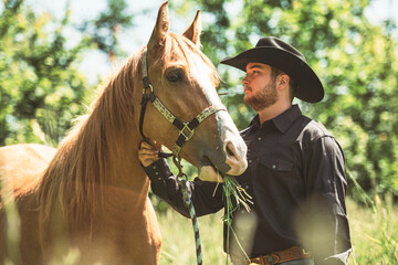 cowboy, stands next to her horse in summer season