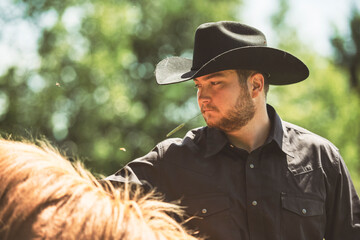 cowboy, stands next to her horse in summer season