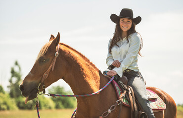 woman cowgirl, stands next to her horse in summer season
