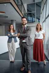 Obraz premium Portrait of business team smiling with arms crossed in office lobby
