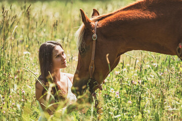 woman cowgirl, stands next to her horse in summer season